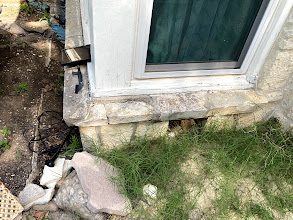 Gaping hole underneath a window sill allowing pests to bypass exterior defenses